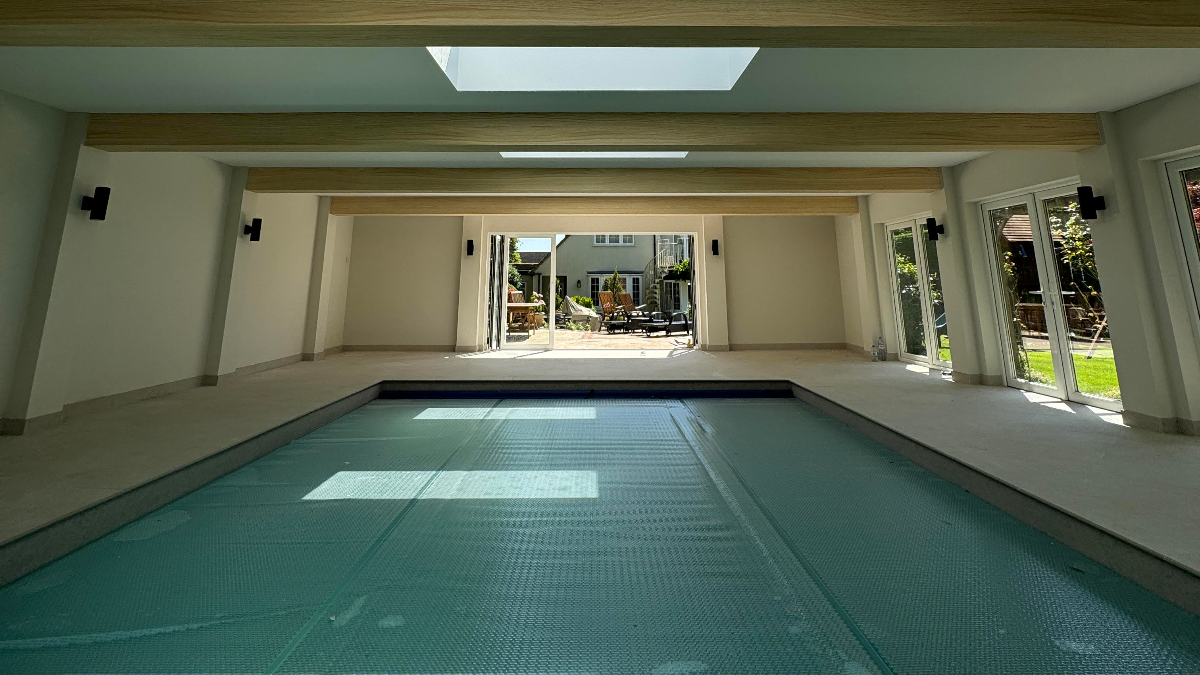 Indoor residential swimming pool with natural light and wall lighting