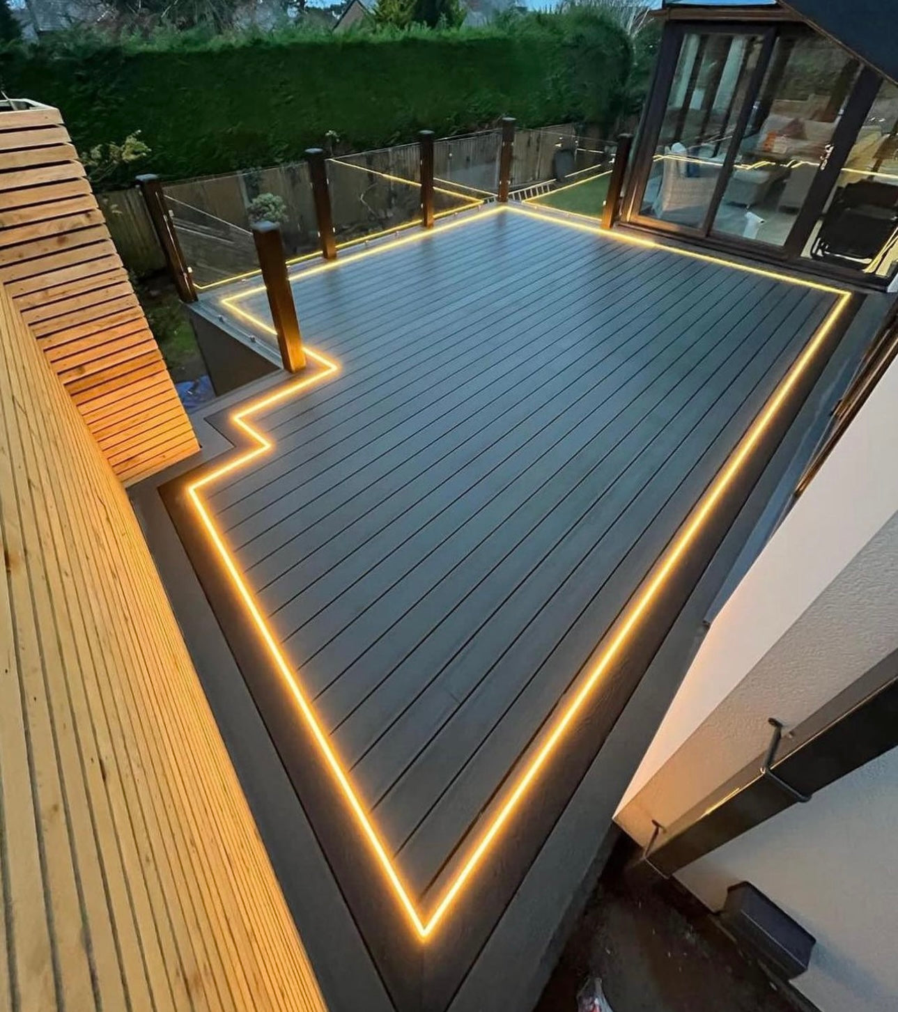 Composite decking with warm white LED strip lighting and glass balustrade